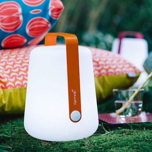 Lamparita recargable Balad by Fermob lista para iluminar en un picnic al exterior en un jardin