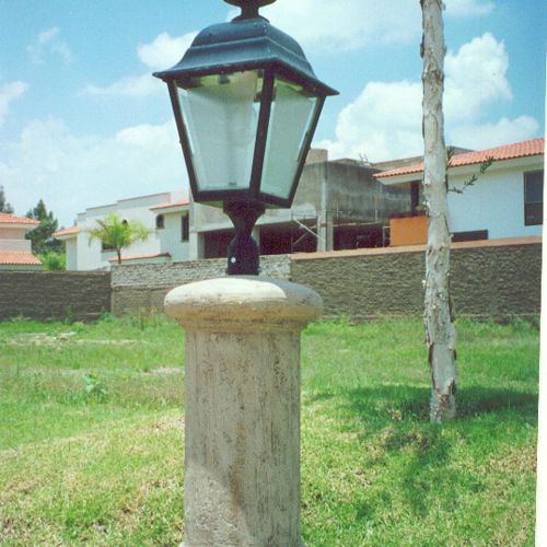 Farolito de fibra de vidrio y columna de cantera en un condominio para iluminar las banquetas