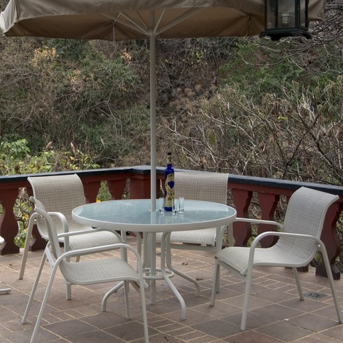 Mesa y sillas de exterior modelo Atenas de aluminio blanco con malla textil en una terraza