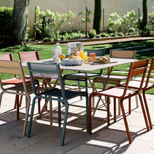 Mesa de jardin Cargo cuadrada plegable de acero en una terraza con sillas Oleron de colores