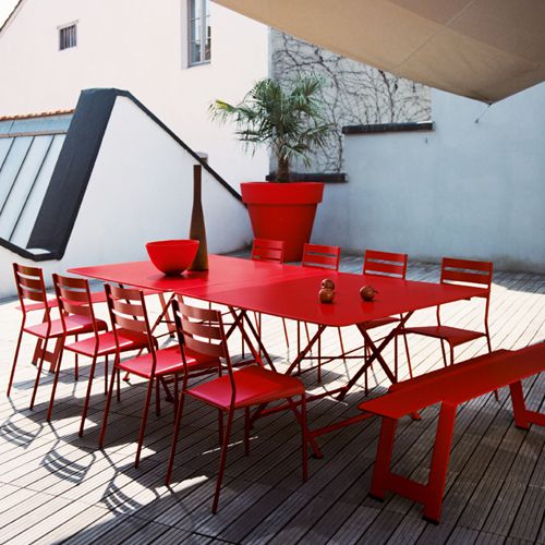 Dos mesas cuadradas Cargo forman mesa rectangular en una terraza al exterior colo rojo
