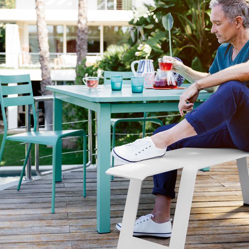 Mesa Craft cuadrada para exterior en una terraza en tono azul laguna