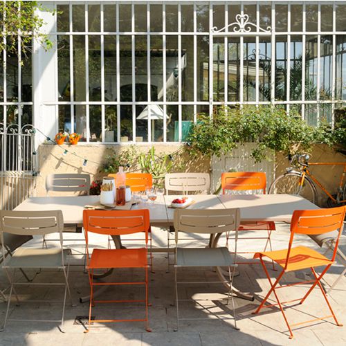Comedor Deauville con sillas Slim todo de Fermob en un jardin o terraza