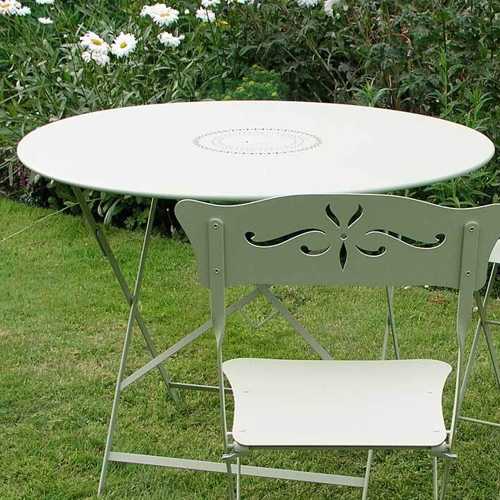 Mesa plegable Floreal en el jardin al exterior color blanca con una silla Bagatelle