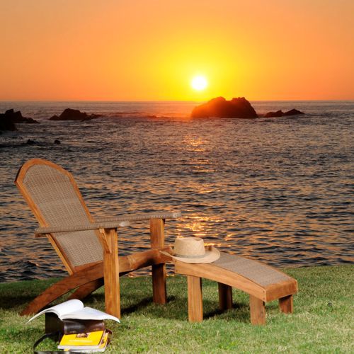 Puesta del sol con muebles de jardin modelo Grosetto de madera y tejido sintetico sobre un jardin frente al mar
