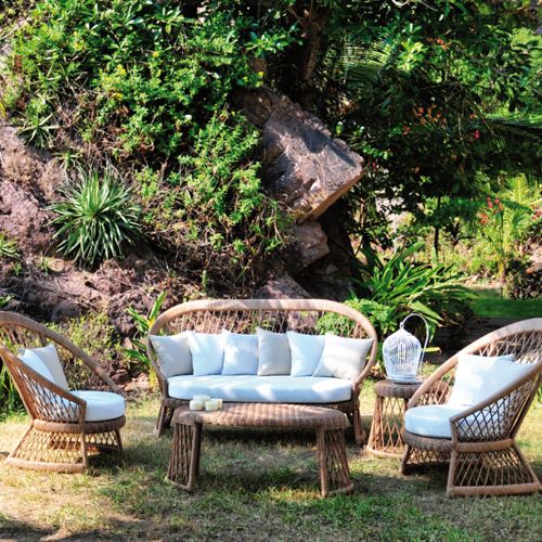 Sala de terraza Haren en un jardin con sillones loveseat y mesita central ovalada y cojines de Tela Sunbrella