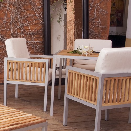 Comedor Ibiza de aluminio y madera teca en una terraza con cojines de tela Sunbrella