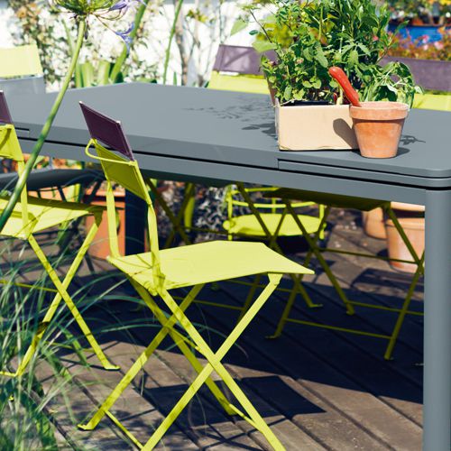 Perfil de silla plegable Latitude en una terraza con respaldo de dos colores