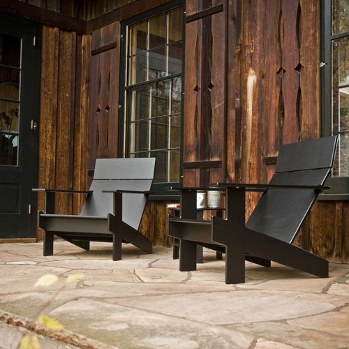 Par de sillones de terraza de plastico reciclado negros modelo Lollygagger en algun jardin al exterior
