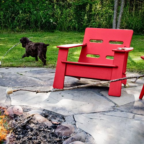 Sillon Cabrio de Loll Designs para exterior en un jardin o terraza con una fogata fabricado de plastico reciclado en color rojo