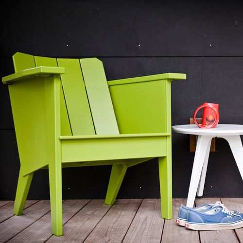 Sillon Lounge individual de Loll Designs de plastico reciclado HDPE de botes de leche en color verde con una mesita lateral redonda