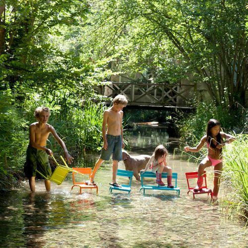 Sillas y banca de jardin para niñso de aluminio de la linea Luxembourg Kids en un rio formando un puente