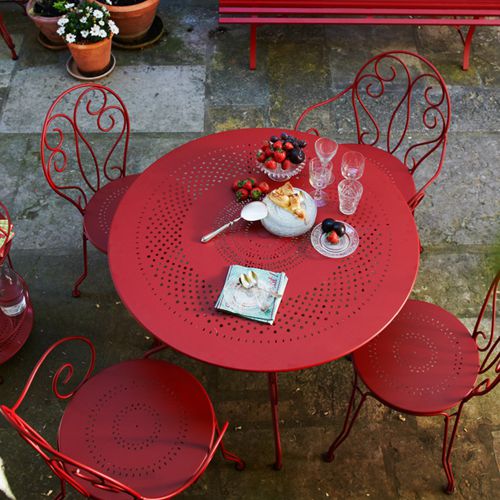 Detalle de un comedor Montmartre de Fermob en color rojo en una terraza o jardin