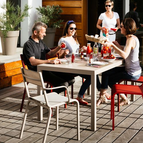 Comedor con sillas apilables de exterior modelo Oleron de colores en una terraza