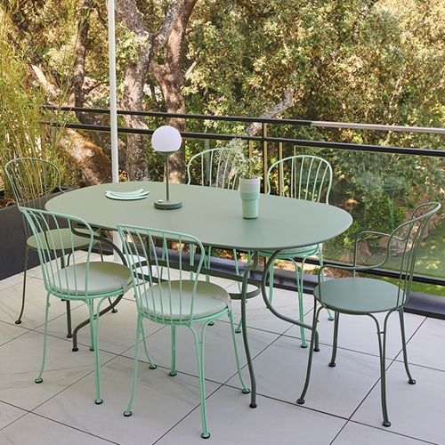 Mesa ovalada con sillas Opera + en una terraza