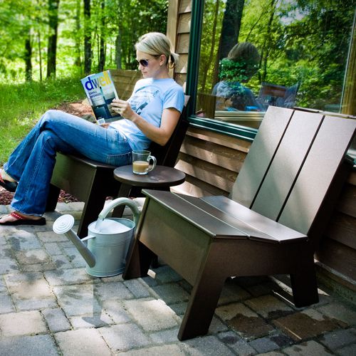 Bancas de jardin Picket ergonomicas de plastico reciclado en una terraza al exterior junto a un bosque fabricadas por Loll Designs