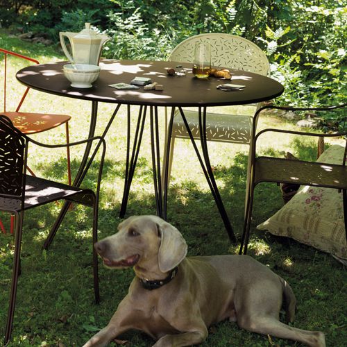 Mesa redonda de exterior y sus sillas en un jardin modelo Rendez Vous by Fermob