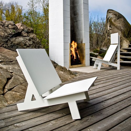 Sillon Taavi diseño de David Salmela para Loll Designs en una terraza frante a una chimenea cl exterior en color blanco