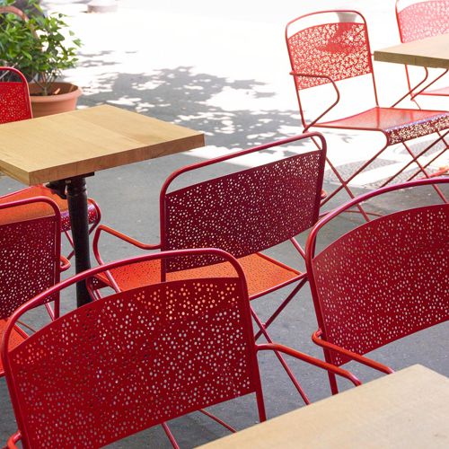 Silla Seville apilable para exterior en un restaurante o café al intemperie en color rojo