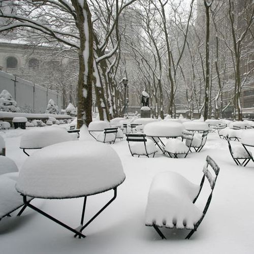 Mesas Tertio y sillas Bistro bajo la nieve en Bryant Park NYC fabricadas por Fermob aguantan uso rudo
