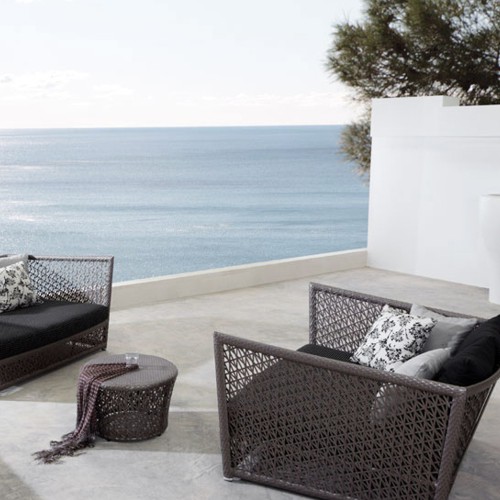 Sillones de exterior modelo Tunis tejidos con plastico de Viro en una terraza frente al mar y con cojines de Tela Sunbrella