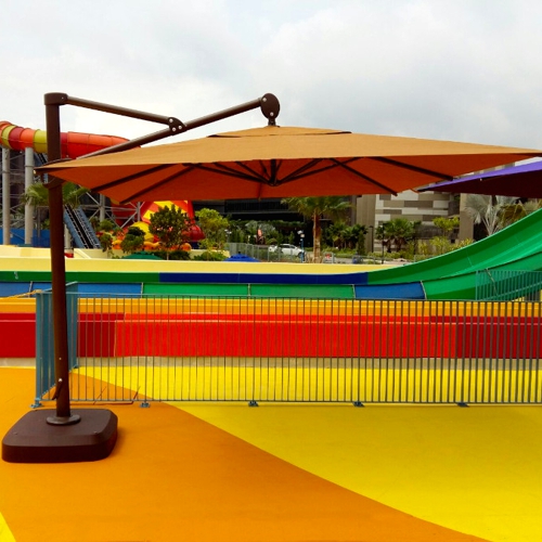 Sombrilla colgante Maku con poste de lado o lateral en un balneario